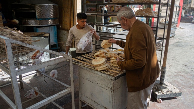 Egyptian men work in a bakery at a market in Cairo, Photographer: Khaled Desouki/AFP/Getty Images