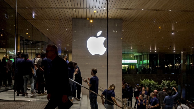 An Apple logo is illuminated as customers walk through the new Apple Inc. Michigan Avenue store during the store's opening in Chicago, in 2017. 
