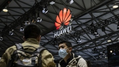 Attendees walk past the Huawei Technologies Co. logo at the MWC Shanghai exhibition in Shanghai, China, on Tuesday, Feb. 23, 2021. Huawei took the wraps off its latest high-end foldable smartphone, hoping to stake out a place in a fast-expanding category despite dwindling expectations that Washington will roll back Trump-era sanctions anytime soon. Photographer: Qilai Shen/Bloomberg
