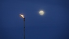 A gas flare burns beside a full moon near the Enbridge Line 5 pipeline in Sarnia, Ontario, Canada, on Tuesday, May 25, 2021. Enbridge Inc. said it will continue to ship crude through its Line 5 pipeline that crosses the Great Lakes, despite Michigan Governor Gretchen Whitmer's order to shut the conduit.