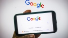 The Google logo on the company's homepage, arranged on an iPhone and a desktop computer in Sydney, Australia, on Friday, Jan. 22, 2021. Google threatened to disable its search engine in Australia if it’s forced to pay local publishers for news, a dramatic escalation of a months-long standoff with the government.
