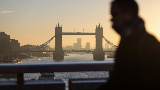 A morning commuter on London Bridge heads towards the City of London, U.K., on Tuesday, Jan. 18, 2022. Britain's labor market grew strongly despite a surge in coronavirus infections late last year, with vacancies hitting a record 1.25 million in the fourth quarter and unemployment falling unexpectedly.