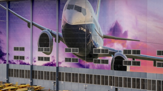 A worker walks under a mural of a Boeing Co. 737-800 airplane outside the company's manufacturing facility in Renton, Washington, U.S., on Monday, March 21, 2022. China Eastern Airlines will ground all of its Boeing 737-800 jets starting Tuesday after a plane crash in the southwestern Chinese region of Guangxi. Photographer: David Ryder/Bloomberg