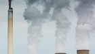 Emissions from a chimney alongside cooling towers of the Eskom Holdings SOC Ltd. Matla coal-fired power station in Mpumalanga, South Africa on Monday, March 21, 2022. A South African court ordered the government to take measures to improve the air quality in a key industrial zone, saying it had breached the constitution by failing to crack down on pollution emitted by power plants operated by Eskom and refineries owned by Sasol Ltd.