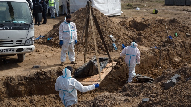 Members of the exhumation team work on a mass grave on April 14, 2022 in Bucha, Ukraine. 