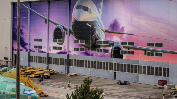A worker walks under a mural of a Boeing Co. 737-800 airplane outside the company's manufacturing facility in Renton, Washington, U.S., on Monday, March 21, 2022. China Eastern Airlines will ground all of its Boeing 737-800 jets starting Tuesday after a plane crash in the southwestern Chinese region of Guangxi. Photographer: Bloomberg/Bloomberg