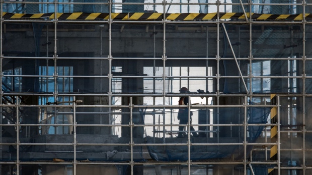 A worker walks past scaffolding at the Sunac Resort project construction site, developed by Sunac China Holdings Ltd., in Haiyan, Zhejiang Province, China, on Friday, Feb. 25, 2022. A widely-anticipated push by China's government to boost construction in order to stabilize growth in the world's second-largest economy has yet to materialize, a blow to hopes that Chinese stimulus would lift global growth early on this year. Photographer: Qilai Shen/Bloomberg