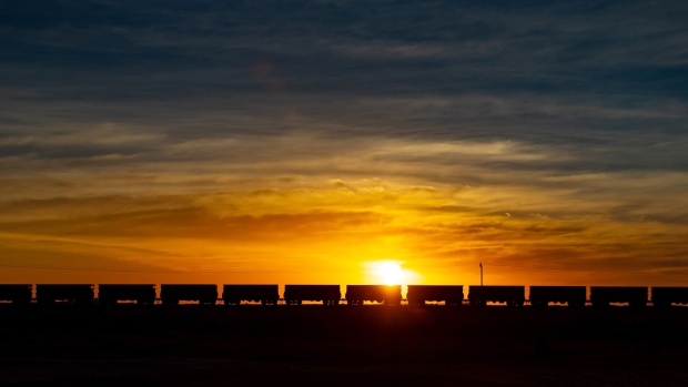 A freight train carrying iron ore is silhouetted as it travels along a rail track near Port Hedland, Australia, on Tuesday, March 19, 2019. A two-day drive from the nearest big city, Perth, Port Hedland is the nexus of Australia’s iron-ore industry, the terminus of one of Australia’s longest private railways that hauls ore about 400 kilometers (250 miles) from the mines of BHP Group and Fortescue Metals Group Ltd. The line ran a record-breaking test train weighing almost 100,000 tons that was more than 7 kilometers long in 2001, and even normal trains haul up to 250 wagons of ore. Photographer: Ian Waldie/Bloomberg