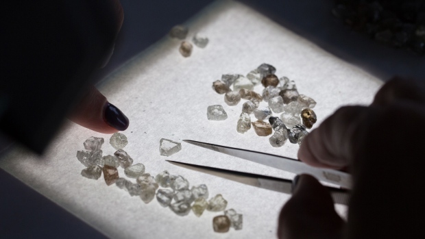An employee sorts through a large collection of rough diamonds on a sorting table at the United Selling Organisation (USO) of Alrosa PJSC sorting center in Moscow, Russia, on Tuesday, Feb. 12, 2019. Alrosa PJSC, one of the world’s top diamond miners, is returning to crisis-stricken Zimbabwe, the latest example of Russia expanding its footprint in Africa.