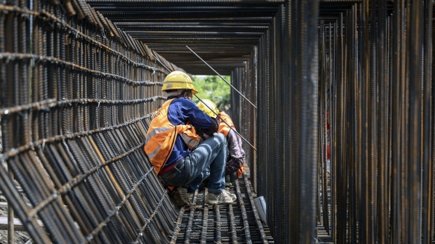 Workers labor at the construction site of an elevated highway on the outskirts of Shanghai. Photographer: Qilai Shen/Bloomberg