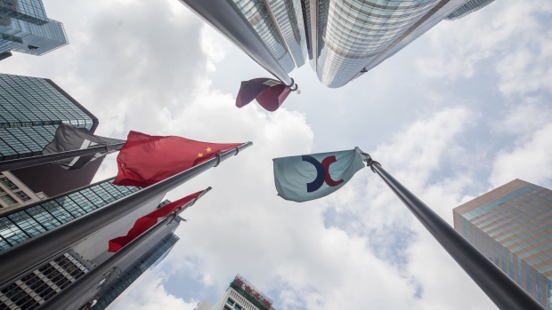 The corporate flag for Hong Kong Exchanges & Clearing Ltd. (HKEX), right, and the Chinese flag, left, fly outside the Exchange Square complex in Hong Kong, China, on Monday, Sept. 16, 2019. The Hong Kong bourse's unsolicited takeover bid for the London Stock Exchange Group Plc was greeted with a scathing rejection and the exchange suffered a further humiliation when China praised the rebuff as well.