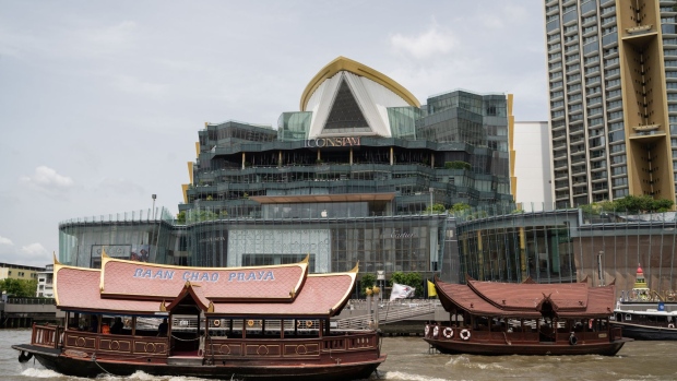 Ferries travel along Chao Phraya River in front of the Iconsiam mega-mall, co-developed by Siam Piwat Group, Magnolia Quality Development Corp. (MQDC) and Charoen Pokphand Group, in Bangkok, Thailand, on Friday, Aug. 16, 2019. Two months of increasingly chaotic protests in Hong Kong are driving investment money out of the city and into Thailand's ultra-luxury condominiums, according to one of the biggest developers in the Southeast Asian country.