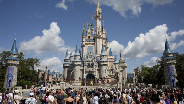 Visitors watch a performance at the Cinderella Castle at the Walt Disney Co. Magic Kingdom park in Orlando, Florida, U.S., on Tuesday, Sept. 12, 2017. The Walt Disney Co. Magic Kingdom park reopenedÂ to a smaller-than-usual crowd after closing for two days and suffering minor storm damage from Hurricane Irma.