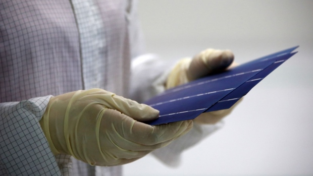 An employee performs a final inspection on solar cells on the production line at the Trina Solar Ltd. factory in Changzhou, Jiangsu Province, China.