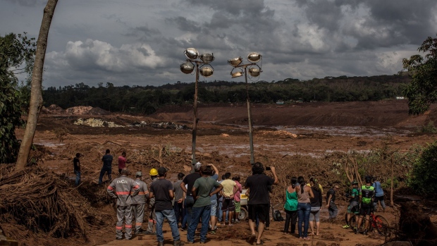 Residents survey damage after a Vale SA dam burst in Brumadinho, Minas Gerais state, Brazil, on Saturday, Jan. 26, 2019. A Brazilian judge has blocked 1 billion reais ($265 million) from Vale SA while environmental authorities imposed a $66 million fine on the miner after a tailings dam it owns burst on Friday in the second deadly accident in the same mining region in just over three years.
