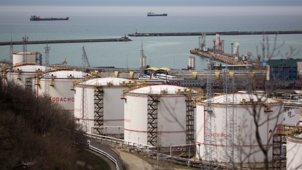Oil storage tanks stand at the RN-Tuapsinsky refinery, operated by Rosneft Oil Co., as tankers sail beyond in Tuapse, Russia, on Monday, March 23, 2020. Major oil currencies have fallen much more this month following the plunge in Brent crude prices to less than $30 a barrel, with Russia’s ruble down by 15%.