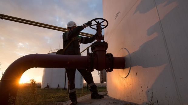 An employee turns a control valve on pipework beside a storage tank at an oil delivery point operated by Bashneft PAO in Sergeevka village, near Ufa, Russia, on Monday, Sept. 26, 2016. Bashneft distributes petroleum products and petrochemicals around the world and in Russia via filling stations.