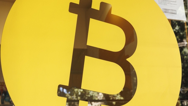 A Bitcoin logo in the window of a Bitcoin Change bureau in Tel Aviv, Israel on Wednesday, Feb. 2, 2022. Bitcoin slipped back after touching a near two-week high, spotlighting the token’s struggle to vault a key technical hurdle and reclaim the $40,000 level. Photographer: Kobi Wolf/Bloomberg