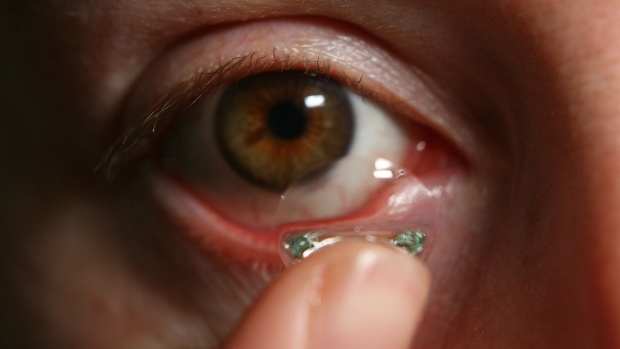 Bloomberg staffer Sara Marley puts in her contact lens at her office in London, U.K., Thursday, May 4, 2006. Photographer: SUZANNE PLUNKETT