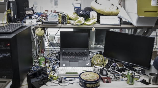 Computer equipment and personal belongings sit on an employee's desk in the research and development department at Bitmain Technologies Ltd.'s headquarters in Beijing, China, on Thursday, Aug. 10, 2017. Bitmain is one of the leading producers of bitcoin-mining equipment and also runs Antpool, a processing pool that combines individual miners from China and other countries, in addition to operating one of the largest digital currency mines in the world. Photographer: Qilai Shen/Bloomberg