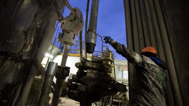 A worker uses a hook to position a drill bit on a drill rig during oil drilling operations by Targin JSC, a unit of Sistema PJSFC, in an oilfield operated by Bashneft PAO near Ufa, Russia, on Thursday, Sept. 29, 2016. Bashneft distributes petroleum products and petrochemicals around the world and in Russia via filling stations.