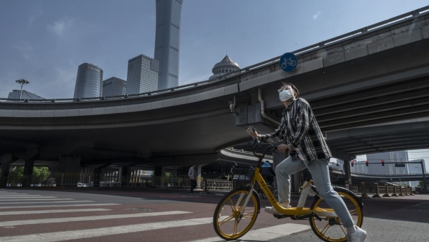 BEIJING, CHINA - MAY 05: A man stops on a shared bicycle at a main intersection during a quiet morning rush hour in the Central Business District, after the government recommended people work from home to prevent the spread of COVID-19, on May 5, 2022 in Beijing, China. China is trying to contain a spike in coronavirus cases in the capital Beijing after dozens of people tested positive for the virus in recent days, causing local authorities to initiate mass testing in most districts, close schools, and ban gatherings and inside dining in all restaurants, and to lockdown some neighbourhoods in an effort to maintain the country's zero COVID strategy. (Photo by Kevin Frayer/Getty Images)