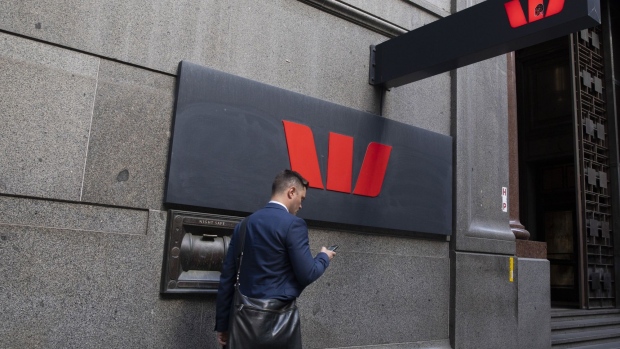 A pedestrian uses a smartphone as he walks past a Westpac Banking Corp. branch in Sydney, Australia, on Monday, Nov. 11, 2019. Australia is bracing for more devastating bushfires, with swaths of the eastern seaboard and even areas of greater Sydney facing a "catastrophic" threat that's unprecedented at this time of year.
