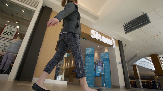 A shopper walks past a Shaw store in the CF Polo Park mall in Winnipeg, Manitoba, Canada, on Monday, March 15, 2021. Rogers Communications Inc. agreed to buy rival Shaw Communications Inc. in a C$20 billion ($16 billion) deal that would unite Canada's two largest cable providers and shake up its wireless industry. Photographer: Shannon VanRaes/Bloomberg