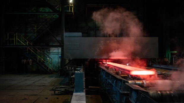 A red hot steel slab moves through a rolling machine during production at the Metinvest Ilych Iron & Steel Works facility in Mariupol, Ukraine, on Thursday, March 7, 2019. Metinvest, a group of steel and mining companies controlled by billionaire Rinat Akhmetov, relied on mines now under separatist control. They produced coal for its Avdiyivka Coke and Chemical Plant, just over the contact line in the government-controlled west. Photographer: Misha Friedman/Bloomberg