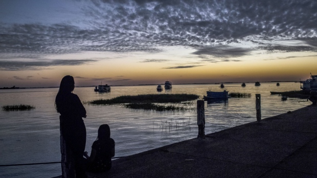 The silhouette of people are seen watching the sun rise over the Tapajos river in Santarem, Para State, Brazil.