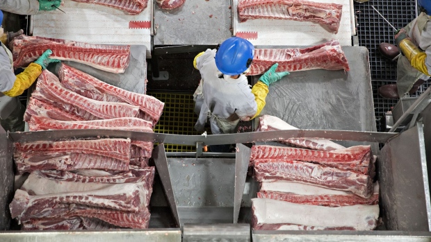 Butchers place pork ribs on a conveyor belt at a Smithfield Foods Inc. pork processing facility in Milan, Missouri, U.S., on Wednesday, April 12, 2017. Photographer: Daniel Acker/Bloomberg