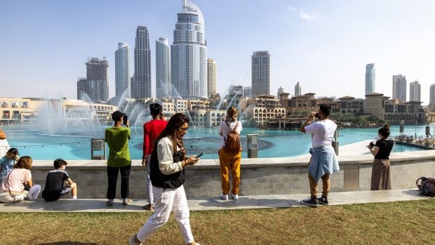 Tourists watch the water fountain display near the Burj Khalifa skyscraper, in Dubai, United Arab Emirates, on Sunday, Jan. 2, 2022. Dubai set out another expansionary budget for this year as the Middle Eastern business hub seeks to offset the impact of the coronavirus pandemic and keep its economy on a growth trajectory.
