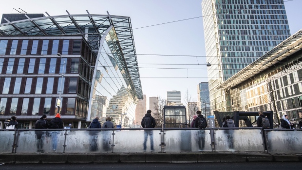 Morning commuters at a tram stop near skyscraper offices in the Zuidas business district in Amsterdam, Netherlands, on Tuesday, March 2, 2021. Amsterdam overtook London as Europe's largest share trading center in January after Brexit saw about half of the city’s volumes move to the continent.