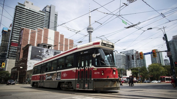 A Toronto Transit Commission (TTC) streetcar travels past the CN Tower in Toronto, Ontario, Canada, on Thursday, Aug. 2, 2018. The TTC had to return 67 out of 89 new streetcars back to Bombardier Inc. for preventative repairs in July, this in a proactive effort by the manufacture to ensure longevity, "all in full transparency with TTC and their riders," a company spokesperson said.