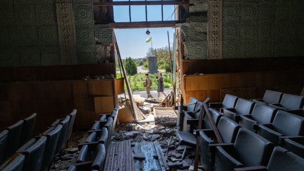 Ukrainian Army Lt. Karyna Skubak, 24, and village leader Dina, 62 walk past a bomb-damaged auditorium in a town which was, until recently, occupied by Russian forces in Kherson Oblast on May 08, 2022 in Zagradivka, Ukraine.