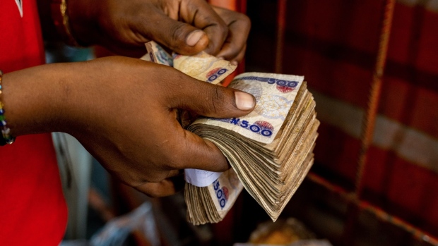 A customer counts out payment from a bundle of 500 Naira banknotes inside a market in Lagos, Nigeria, on Friday, April 22, 2022. Choked supply chains, partly due to Russia’s invasion of Ukraine, and an almost 100% increase in gasoline prices this year, are placing upward price pressures on Africa’s largest economy.
