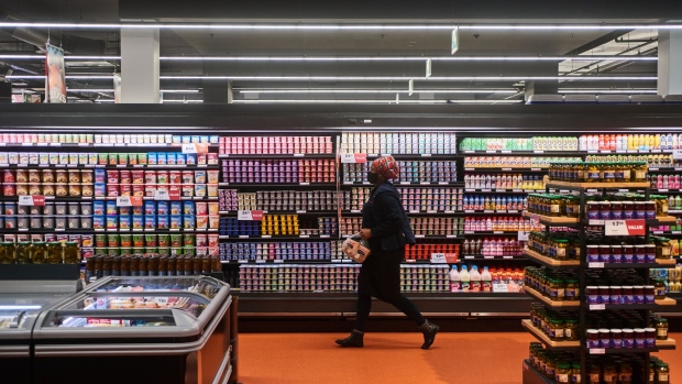 A shopper carries items from the refrigerated dairy shelf inside a Checkers supermarket, operated by Shoprite Holdings Ltd., in Rosebank shopping mall in Johannesburg, South Africa, on Friday, Feb. 18, 2022. South Africa's economy showed surprising resilience through 2021, but the luster has started to fade, with Bloomberg Intelligence forecasting GDP growth of less than 2% for 2022.