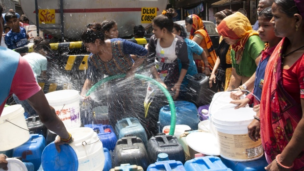Residents fill water from a water tanker in Kusumpur Pahari slum in New Delhi, India, on Friday, May 13, 2022. Large parts of northern and central India are bracing for more days of brutal heat, with temperatures forecast to hit 50° Celsius later in the week.