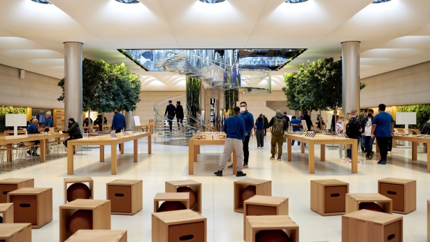 Employees assist customers during a sales launch at the Apple Inc. flagship store in New York, U.S., on Friday, March 18, 2022. The debut of Apple Inc.’s latest iPhone brings a change to the way its U.S. customers can purchase the device, a move toward cutting wireless carriers out of the process and giving the tech giant more control.