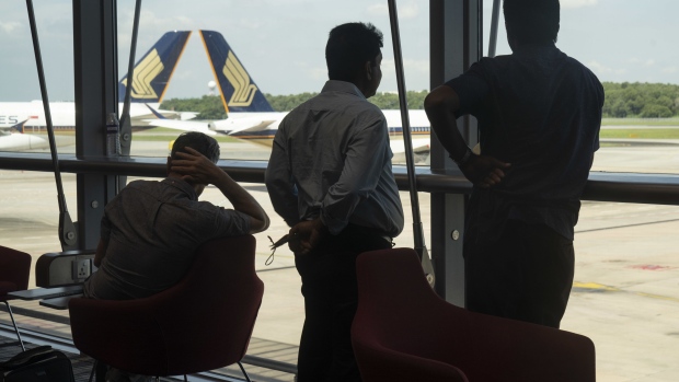 Travelers in a waiting area near Singapore Airlines Ltd. aircraft at Changi Airport in Singapore, on Wednesday, March 30, 2022. Starting April 1, Singapore will scrap its so-called vaccinated travel lanes and admit all vaccinated travelers who test negative before entering Singapore by air or sea and they will be exempted from quarantine or testing on arrival.