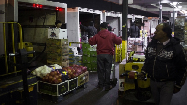 Workers load produce onto trucks for transport at the Hunts Point Terminal Produce Market in the Bronx borough of New York. Photographer: John Taggart/Bloomberg