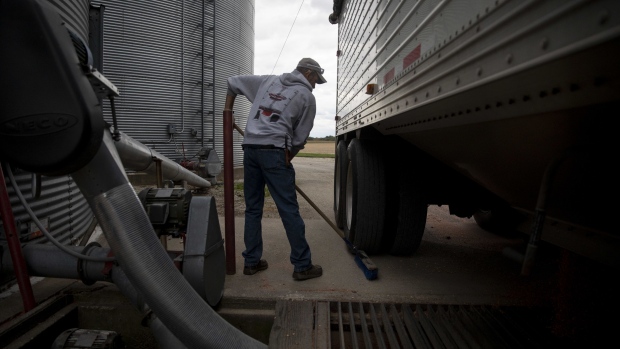 A worker sweeps after unloading corn from a grain truck in Princeton, Illinois, U.S., on Tuesday, Sept. 29, 2020. December corn futures up 3.4% to $3.77 1/4 a bushel, on pace for the biggest gain for the contract since mid-August.