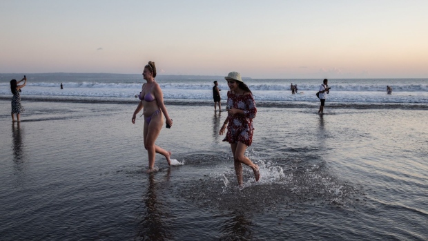 Tourists at a beach in Seminyak, Bali, Indonesia, on Friday, May 6, 2022. With the broader reopening, fully vaccinated visitors from overseas to Bali no longer need to quarantine.