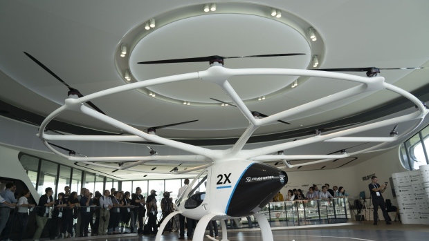 The Volocopter 2X, developed by Volocopter GmbH, sits on display at a VoloPort model flying taxi station, built by Skyports Ltd., during an event jointly hosted by Skyports and Volocopter at The Float at Marina Bay in Singapore, on Monday, Oct. 21, 2019. Flying taxis, once the purview of science-fiction films such as The Fifth Element, might soon be a staple of urban transport, as better batteries and innovative designs make it cheaper, cleaner, and quieter to travel short distances by air.