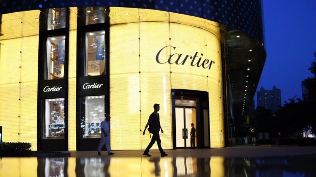 A pedestrian walks past a Cartier store, operated by Cie. Financiere Richemont SA, as it stands illuminated at night in Shanghai, China, on Tuesday, July 2, 2013. Banks including Goldman Sachs Group Inc. have pared their growth projections for China this year to 7.4 percent, below the government's 7.5 percent goal disclosed at the March conference at which Li Keqiang became premier. Photographer: Bloomberg/Bloomberg