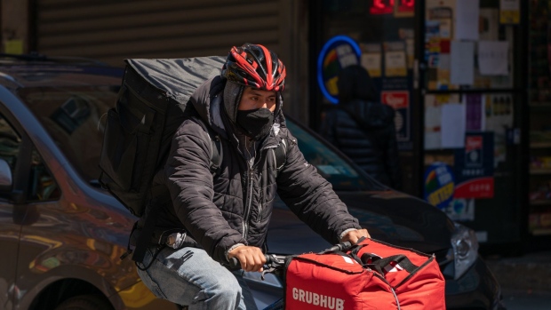 A food delivery courier for Grubhub Inc. wears a protective mask in New York, U.S., on Monday, April 6, 2020. New York Governor Andrew Cuomo said deaths from the coronavirus pandemic were showing signs of hitting a plateau in the state that has become the epicenter of the U.S. outbreak.