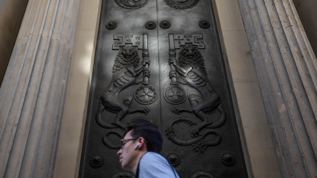 A pedestrian walks past the doors of the Bank of England (BOE) in the City of London, U.K., on Tuesday, Aug. 4, 2020. Bank of England officials could signal on Thursday that the case for more monetary stimulus is growing as a nascent rebound from the pandemic-induced recession risks fading.