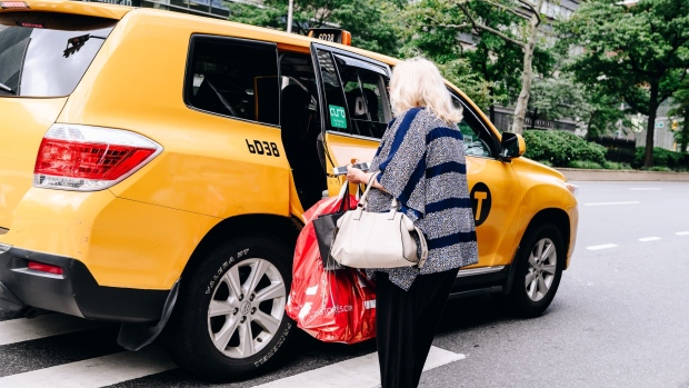 A shopper carrying a bag enters a taxi outside a Century 21 department store in New York, U.S., on Friday, Sept. 11, 2020. Century 21 Stores, an iconic New York off-price department store chain, filed for bankruptcy with plans to shut down, becoming the latest victim of the retail industry carnage that's accelerated during the pandemic.