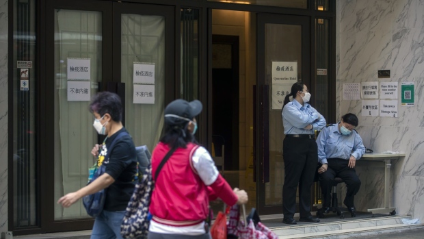 Security officers outside a quarantine hotel in Hong Kong, China, on Tuesday, March 1, 2022. Hong Kong is planning to enforce a lockdown to ensure a mandatory Covid-19 testing drive planned for this month is effective, Sing Tao Daily and other domestic media reported Tuesday, as the worst virus outbreak in the city so far continues to snowball.