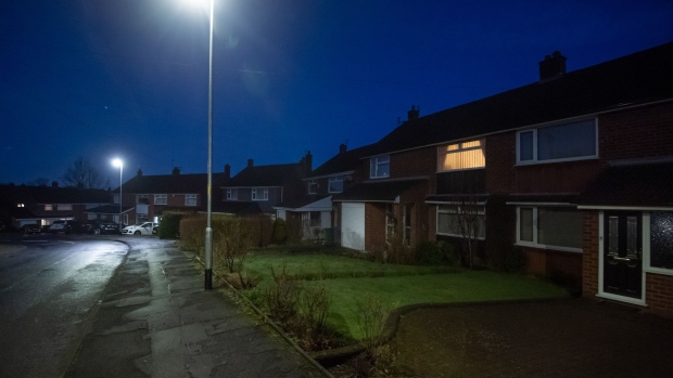 A light on at a residential house at dawn in the Stalybridge district of Greater Manchester, U.K. Photographer: Anthony Devlin/Bloomberg
